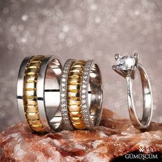 three wedding rings sitting on top of a rock