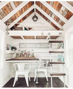 the inside of a small room with white furniture and wood paneling on the ceiling