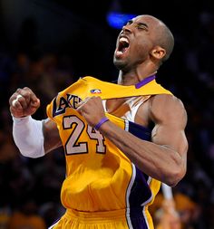 a basketball player is holding his jersey in the air and yelling at someone behind him