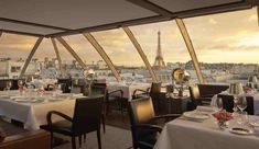 a dining area with tables and chairs overlooking the eiffel tower