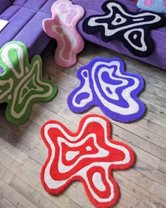 colorful rugs are laid out on the floor next to a purple couch and coffee table