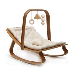 a wooden rocking chair with a white cushion on the seat and some balls hanging from it