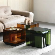 three glass tables sitting next to each other on a white carpeted floor in front of a couch