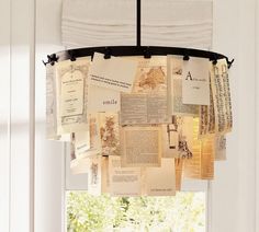 a black and white photo of some papers hanging from a light fixture in a window