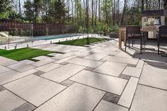 an outdoor patio with grass and pool in the background