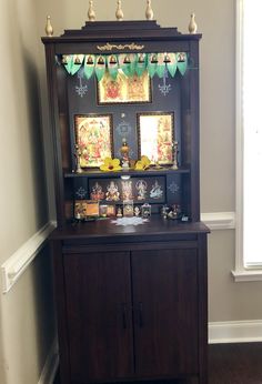 a wooden cabinet with pictures and decorations on it