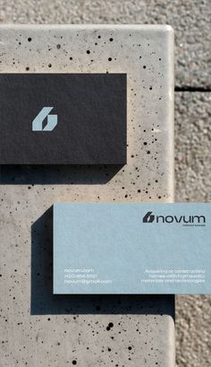 two business cards sitting on top of cement