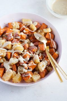 a white bowl filled with food next to a spoon