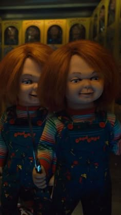 two creepy dolls standing next to each other