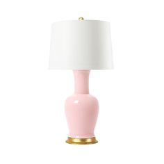 a pink and gold lamp with a white shade on the top is sitting in front of a white background