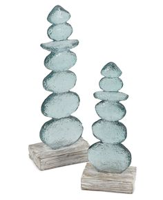 two blue glass rocks sitting on top of each other in front of a white background