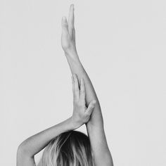 a black and white photo of a woman with her hands up in the air above her head