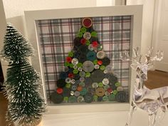 a christmas tree made out of buttons in a frame