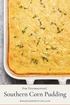 a casserole dish filled with corn pudding and topped with fresh rosemary sprigs