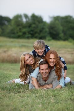 a man, woman and child are laying in the grass