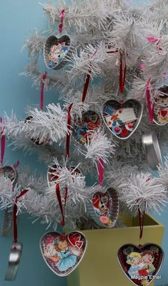 a white christmas tree with heart shaped ornaments hanging from it's branches and tinsel