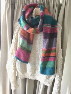 a multicolored scarf hanging on a clothes rack