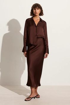 Embracing 90's inspired slip forms, the Ancora Skirt boasts a midi bias cut silhouette designed with a high-rise and elasticated waistband for easy-wear. This style is crafted from responsibly sourced viscose satin and hand-dyed in Dark Truffle Brown. Style it with the Francisa Shirt for elevated set dressing or with a white tee for an effortless daytime look. 90s Skirt Set, Dark Brown Outfit, Satin Slip Skirt, Bias Cut Skirt, Brown Satin, Faithfull The Brand, Maxi Dress Sale, Slip Skirt, Collar Designs