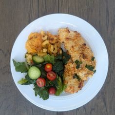 a white plate topped with meat and veggies on top of a wooden table