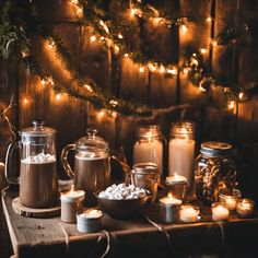 hot chocolates, marshmallows and candles on a table