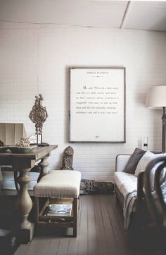 a living room filled with furniture and a white brick wall