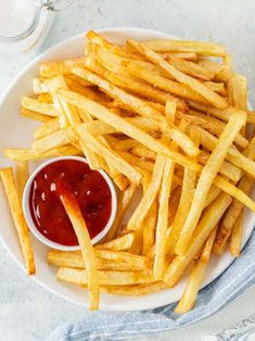 french fries on a plate with ketchup and sauce