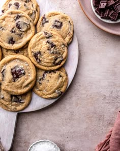 chocolate chip cookies are on a plate next to milk