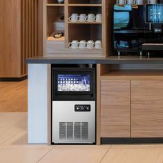 a coffee machine sitting in the middle of a kitchen next to a counter with cups on it