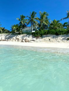 the water is crystal blue and clear with palm trees in the background on this tropical beach