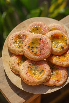 a plate full of cookies with different toppings on them sitting on a wooden table