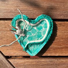 a decorative heart shaped dish sitting on top of a wooden table