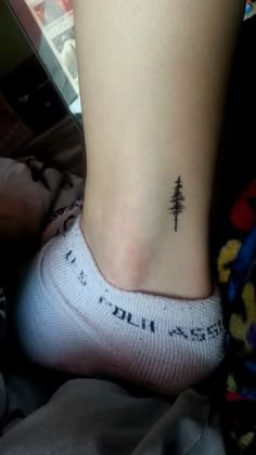 a small pine tree tattoo on the ankle