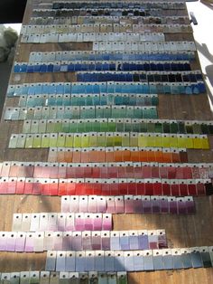 many different colors of paint sitting on top of a wooden table next to each other