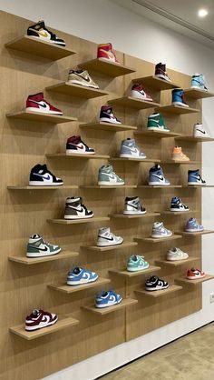 a wall filled with lots of different types of shoes on shelves next to each other