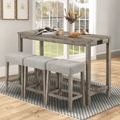 a dining room table with two stools and a book on the end shelf next to it