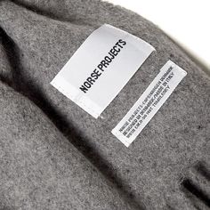 a label on the back of a gray sweater with white writing that reads, modest projects