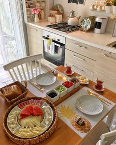 a wooden table topped with plates and bowls filled with food next to a stove top oven