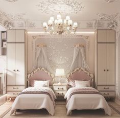 two beds in a room with chandeliers on the ceiling