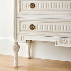 an old white dresser with gold knobs on the handles and drawer pulls is shown