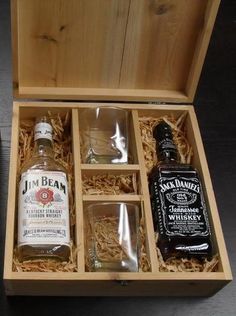 an open wooden box containing two bottles of whiskey and a bottle of whisky in it