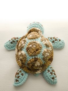 a crocheted turtle sitting on top of a white surface