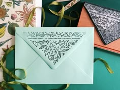 an envelope with a stamp on it sitting next to some ribbons and other items that include scissors