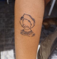 a woman's arm with a tattoo on it that has a drawing of a man