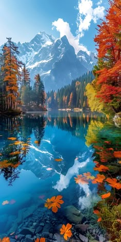 an autumn scene with mountains and trees reflected in the water