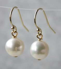 A stunning, simple and elegant white freshwater pearl dangle hook earrings Approximately 9mm near round freshwater pearls on gold-filled earring hooks. The earrings is approximately 2.2cm long  Gold filled is a thick layer of gold physically bounded by heat and pressure to a layer of nickel free base metal (commonly brass or copper). The layer of gold is much thicker than a normal electroplated coating. Gold filled is much more valuable than and more tarnish resistant than gold plated, doesn't f Freshwater Pearls Earrings, White Freshwater Pearl, Drop Dangle Earrings, Earrings White, Earring Hooks, Pearl Color, Pearl Drop, Hook Earrings, White Pearl