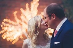 a bride and groom kissing in front of fireworks