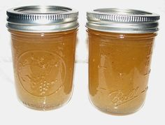 two mason jars filled with liquid sitting on top of a table