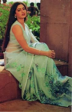 a woman is sitting on the steps in a green dress