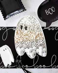 a black and white table topped with lots of marshmallows in the shape of a boat