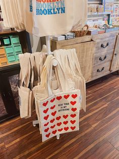 there are many bags on display in the store, including one with red heart stickers